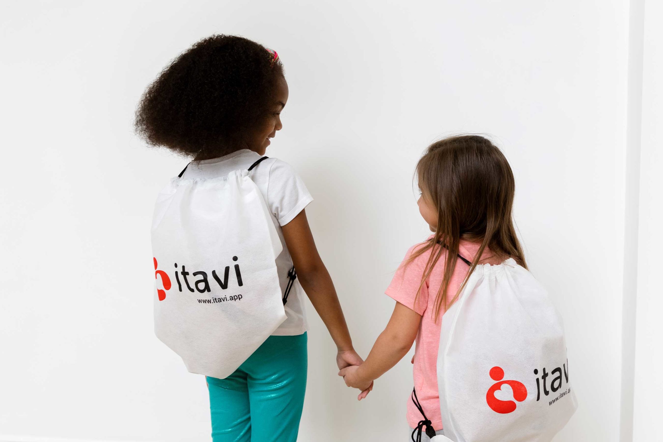 kids with their itavi bags holding hands